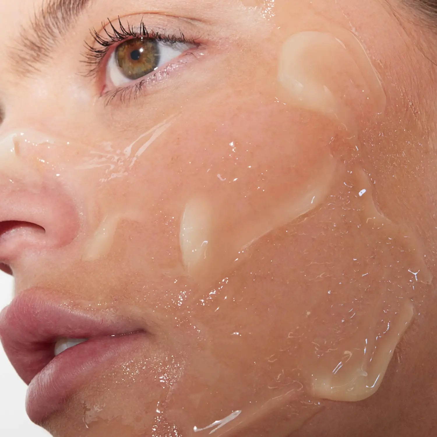 Primer plano de un rostro con el bálsamo limpiador Perricone MD Essential Fx Chia en las mejillas y la mandíbula.