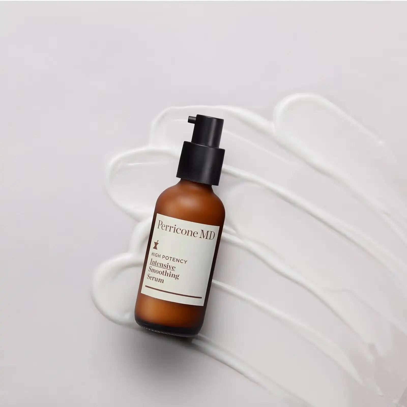 Frasco del sérum colocado sobre una extensión de producto blanco que muestra su textura ligera.